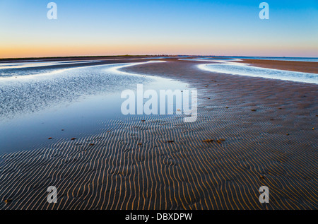 Das Wellenmuster auf dem Sand war sanft beleuchtet, wenn die Sonne in Bolivar-Halbinsel in Texas untergeht. Stockfoto