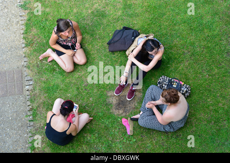 Gruppe von jungen Studenten sitzen am Ufer an Göring Schleuse Goring-on-Thames, Oxfordshire, England, Vereinigtes Königreich Stockfoto