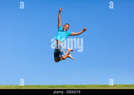 Outdoor-Porträt von einem niedlichen schwarzen Teenager springen über einen blauen Himmel - afrikanische Bevölkerung Stockfoto