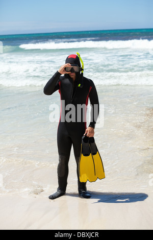 männlichen Taucher mit Taucheranzug Schnorchel Maske Flossen am Strand im Sommer Stockfoto