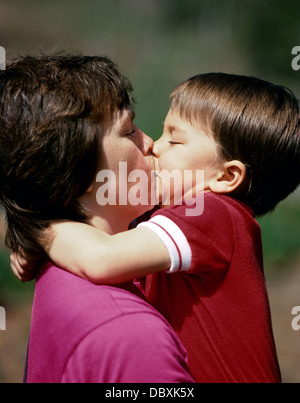 Kleiner Junge gibt seine Mutter einen dicken Kuss. Stockfoto