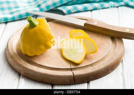 geschnittene gelbe Patisson am Küchentisch Stockfoto