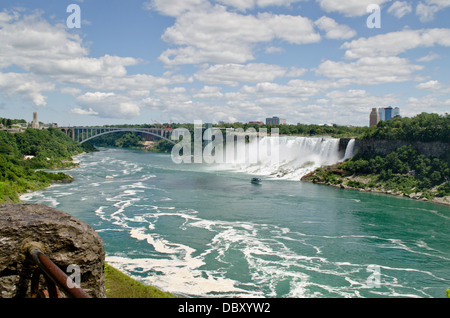 Blick von der kanadischen Seite von Niagara Falls.  Gesehen sind die amerikanischen Wasserfälle, Rainbow Bridge und eine Magd des Bootes Nebel. Stockfoto