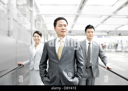 Zuversichtlich Geschäftsleute auf Flughafen Rolltreppe Stockfoto