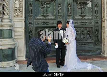 Asian paar haben Hochzeitsfotos an den Türen der Basilika di Santa Maria del Fiore in Florenz, Italien. Stockfoto