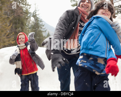 Vater und Söhne genießen Schneeball kämpfen Stockfoto