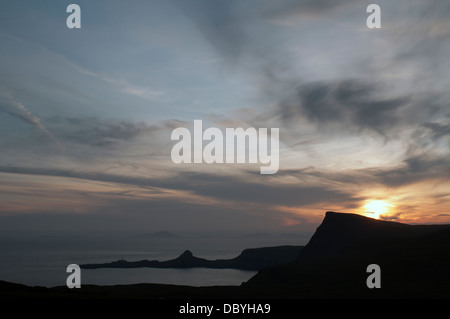 Sonnenuntergang über Waterstein Head und Neiss Point, Duirinish Küste, Isle Of Skye, Schottland. Western Isles sichtbar in der Ferne. Stockfoto