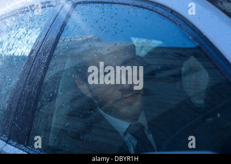 Nahaufnahme von Geschäftsmann in Auto blickte zu Regen Stockfoto