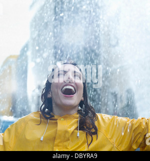 Begeisterte Frau im Regen stehen Stockfoto