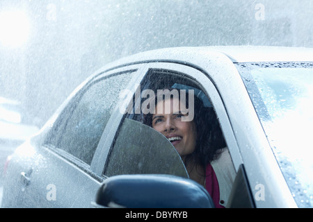 Geschäftsfrau im Auto Regen blickte lächelnd Stockfoto