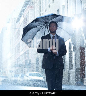 Kaufmann unter Dach im verregneten Straße Stockfoto