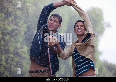 Glückliche Paare tanzen im Regen Stockfoto