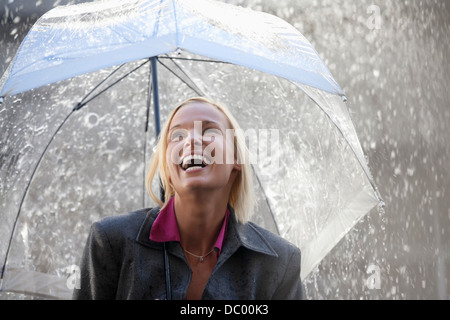 Lachend Geschäftsfrau unter Dach im Regen Stockfoto