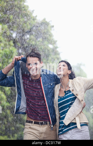 Glückliches Paar zu Fuß in Regen Stockfoto