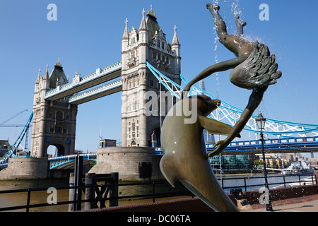 David Wynnes Mädchen mit einer Delfin-Statue vor der Tower Bridge London England UK Stockfoto