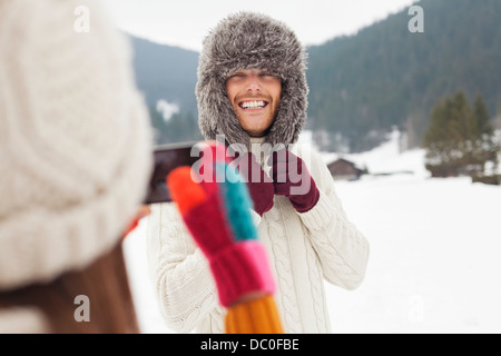 Frau Mann tragen Pelzmütze in schneebedeckten Feld fotografieren Stockfoto