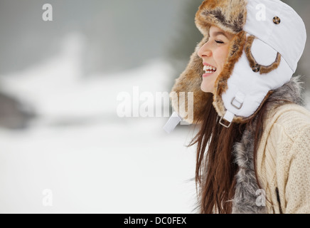 Glückliche Frau Pelz Hut im Schnee Stockfoto