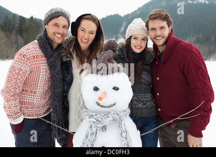 Porträt der happy Friends mit Schneemann Stockfoto