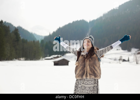 Unbeschwerte Frau mit ausgestreckten in schneebedecktes Feld Stockfoto