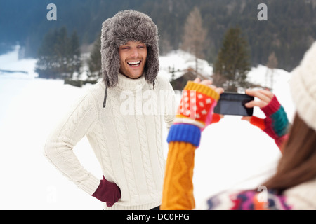 Frau Mann in Pelzmütze in schneebedeckten Feld fotografieren Stockfoto