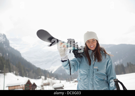 Porträt von begeisterte Frau, die Skier in schneebedecktes Feld Stockfoto