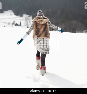 Frau zu Fuß in schneebedecktes Feld Stockfoto