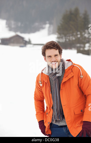 Porträt von lächelnden Mann in schneebedecktes Feld Stockfoto