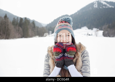 Porträt von begeisterten Trägerin stricken, Mütze und Handschuhe in schneebedecktes Feld Stockfoto