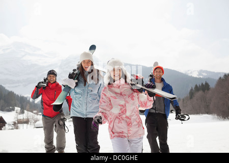 Begeisterte Freunde mit Skiern in schneebedecktes Feld Stockfoto