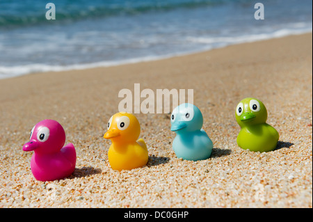 Buntes Spielzeug Enten in den Sand am Strand Stockfoto