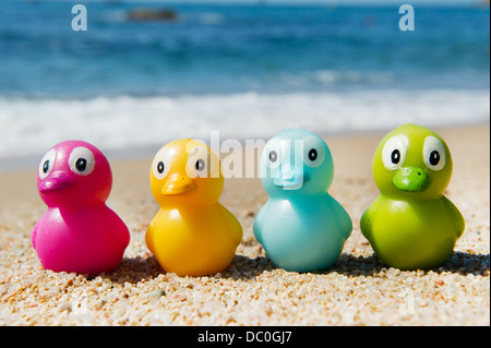 Buntes Spielzeug Enten in den Sand am Strand Stockfoto