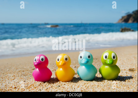 Buntes Spielzeug Enten in den Sand am Strand Stockfoto