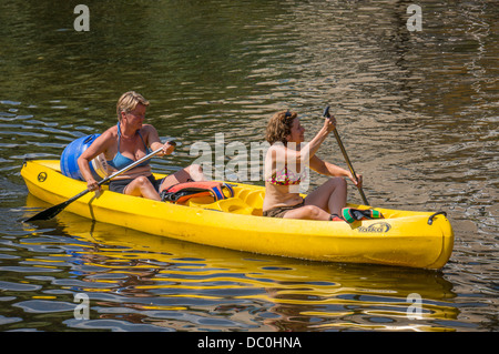Zwei Frauen, die Freunde in ein Kanu auf dem Fluss Dronne n der Ortschaft Brantôme, in der Dordogne im Südwesten Frankreichs, Europa. Stockfoto
