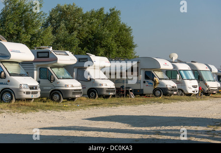 Eine Reihe von Wohnmobilen mit Blick auf die Sonne und die Nacht auf dem Aire de camping geparkt, Le Crotoy, Somme, Picardie, Frankreich, Europa. Stockfoto