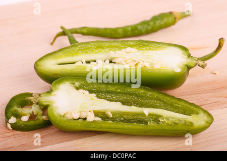 Schnitt, in Scheiben geschnitten und ganze Jalapeno und Cayennepfeffer auf Holz Schneidebrett Stockfoto