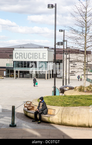 Ein Mann sitzt im Tudor Platz und Crucible Theatre Baujahr 1971 im Stadtzentrum von Sheffield, South Yorkshire Stockfoto