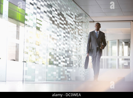 Geschäftsmann mit Aktenkoffer zu Fuß in lobby Stockfoto