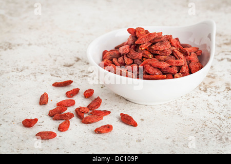 kleine Keramikschale getrocknete Goji Beeren vor dem Hintergrund der keramischen Fliese mit einem Textfreiraum Stockfoto