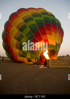 Hot Air Balloon liegend wird aufgeblasen im Morgengrauen in Luxor, Ägypten Stockfoto