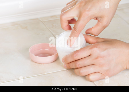 Horizontale Foto Vorderseite des weiblichen Zeigefinger eintauchen in kosmetische Creme hautnah Stockfoto