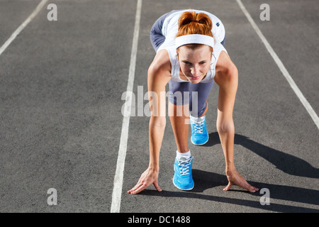 Frau, die immer bereit zu starten auf Stadion - Sommer im freien training. Stockfoto