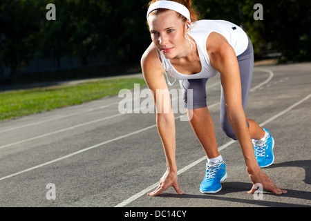 Frau, die immer bereit zu starten auf Stadion - Sommer im freien training. Stockfoto