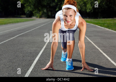 Frau, die immer bereit zu starten auf Stadion - Sommer im freien training. Stockfoto