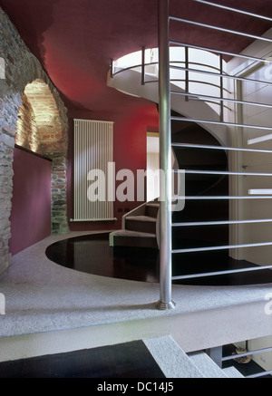 moderne Wendeltreppe mit Steinmauer und Marmorboden Stockfoto