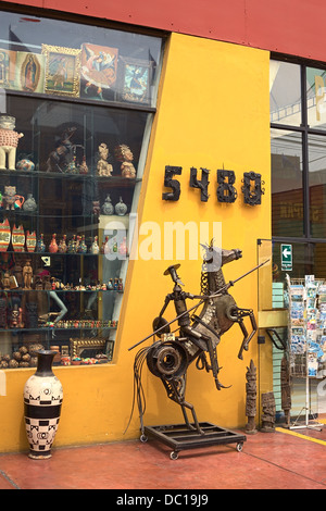 Eine Skulptur aus Metall, Postkarten und eine Vase außerhalb einen Souvenir-Shop in Miraflores, Lima, Peru Stockfoto