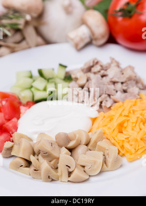 Salat aus geschnittenem Gemüse, Fleisch und Champignons mit Garnitur auf weißer Teller Stockfoto