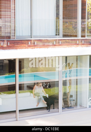 Frau und Hund am Fenster des modernen Hauses Stockfoto