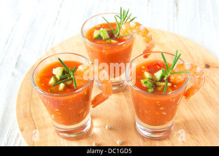 Lecker lecker kalte Tomaten Suppe Gazpacho in Teil Gläsern mit Garnelen auf Holzbrett, Closeup, horizontal Stockfoto