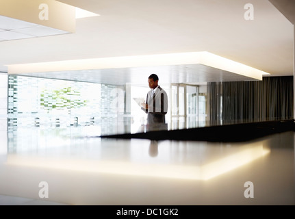 Silhouette der Geschäftsmann mit digital-Tablette in lobby Stockfoto