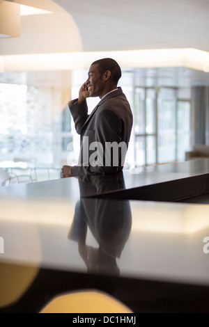 Lächelnde Geschäftsmann reden über Handy in lobby Stockfoto